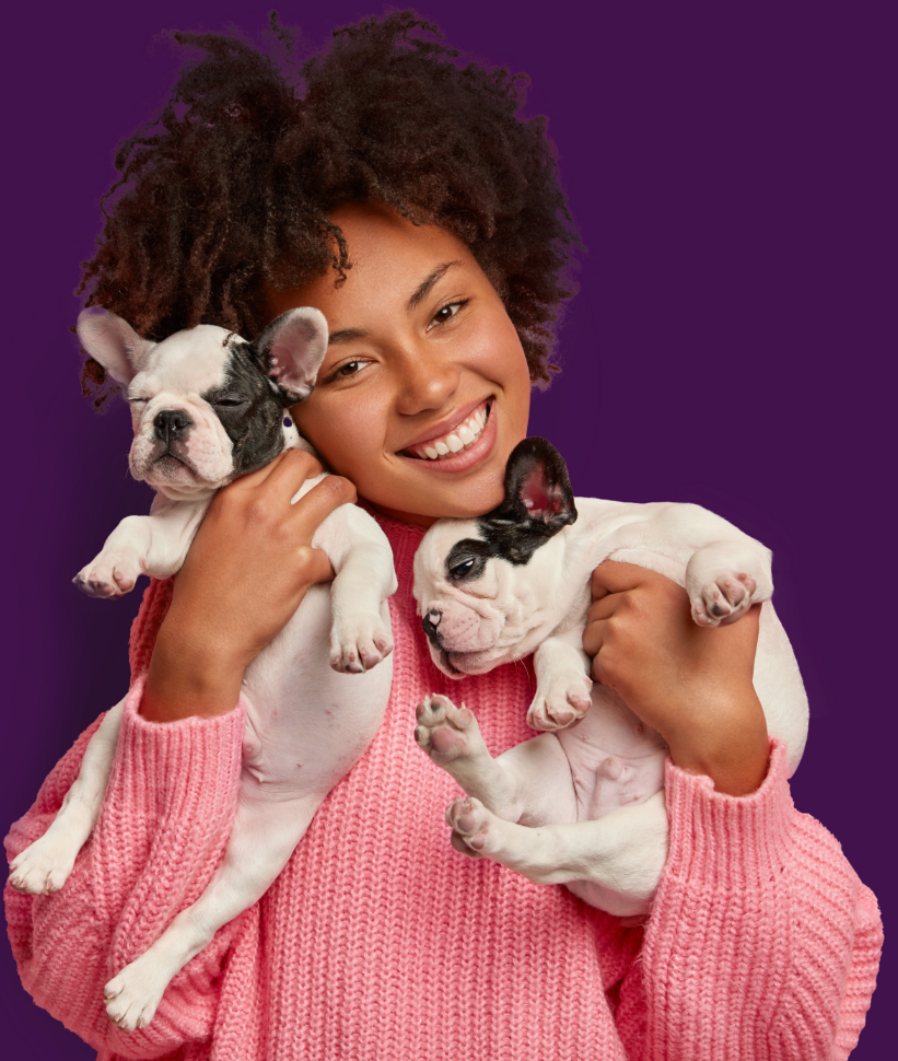 Mulher segurando dois cachorros.
